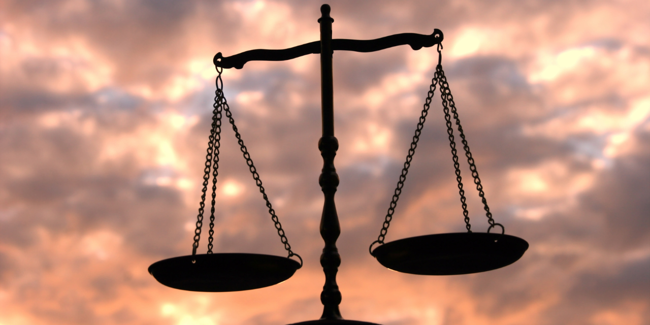 Balance Scale Against Multi-Colored Sky
