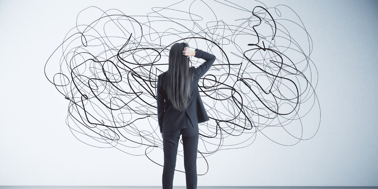 A woman looking at a abstract scribble on a wall. Confusion and doubt concept.