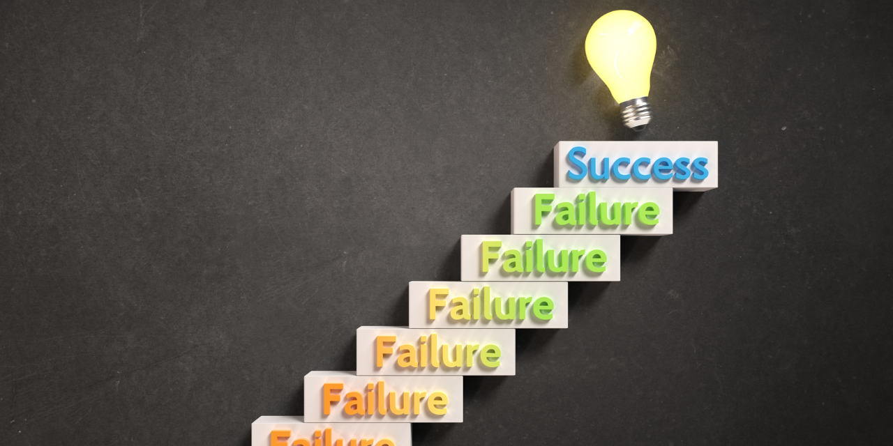 the words "failure" in a diagonal line with "success" at the top with a light bulb.