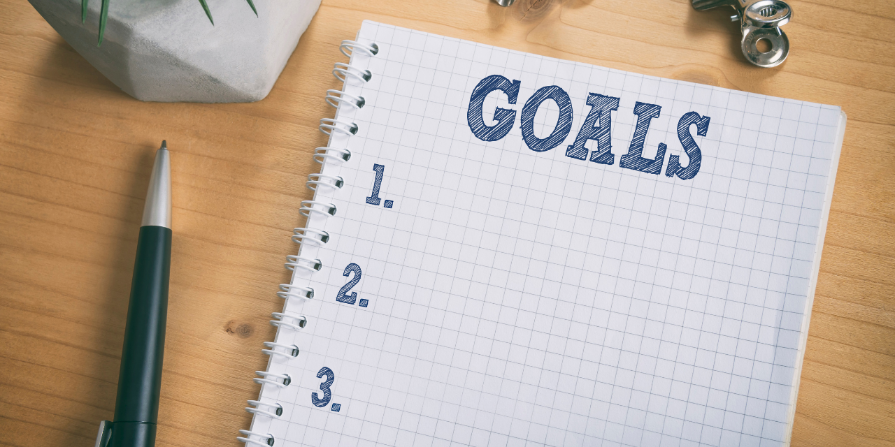goal list with notebook on wooden desk