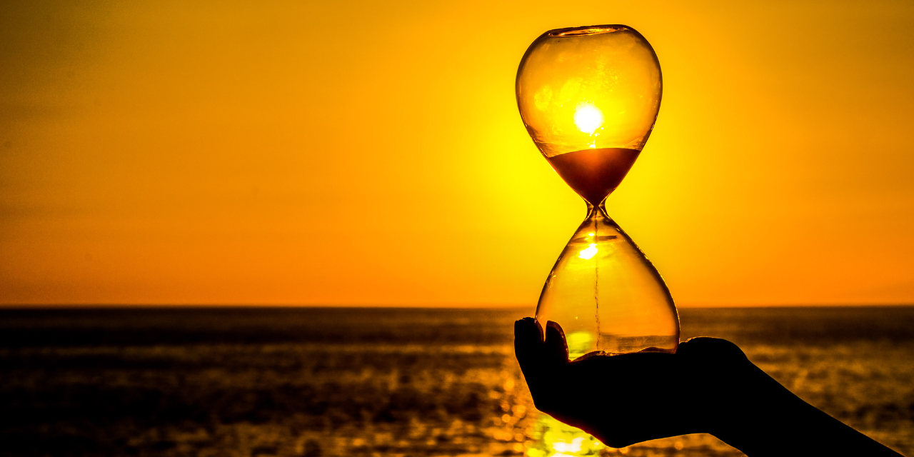 time concept hourglass and sunset facing the ocean